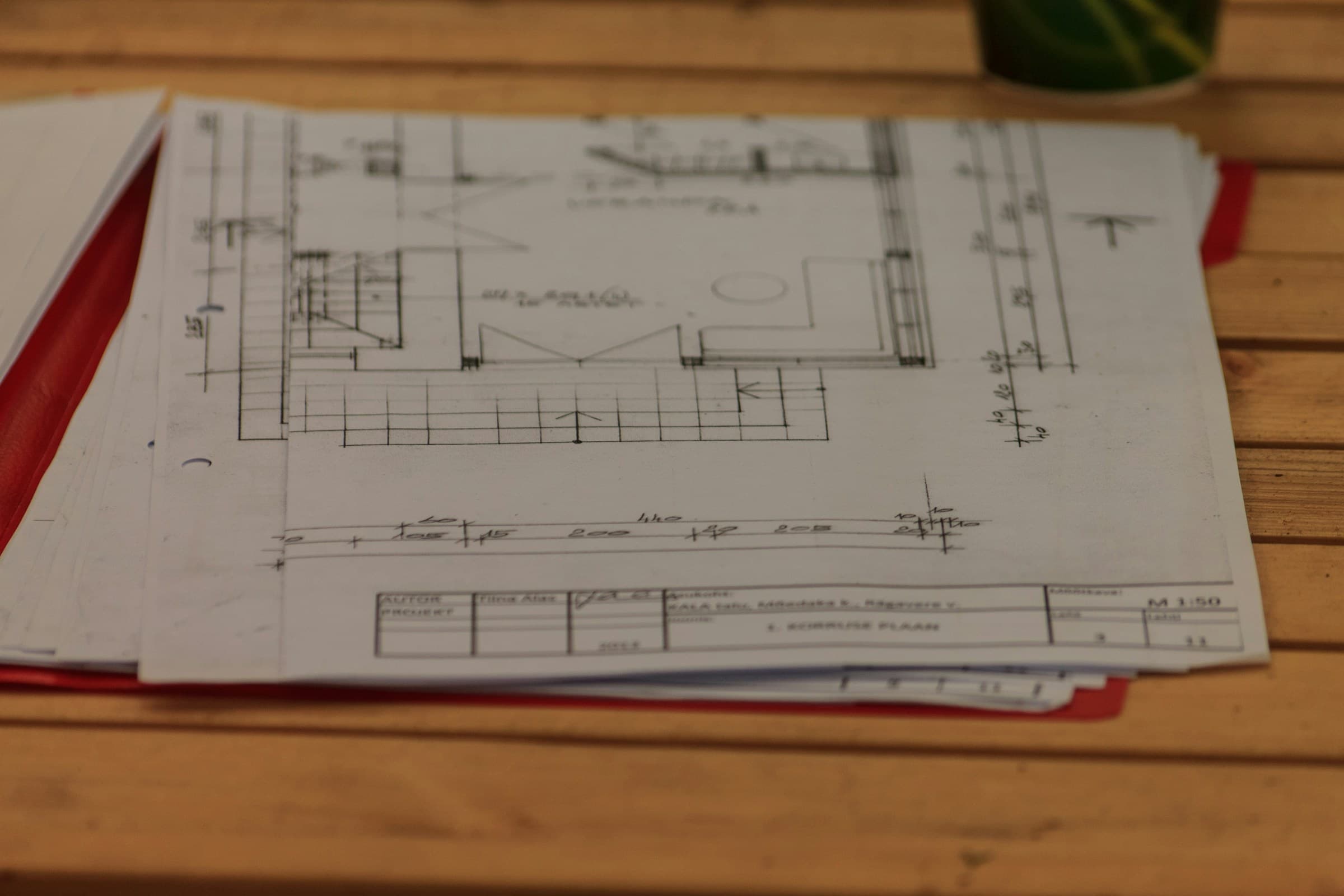 Architectural drawings spread across a wooden table