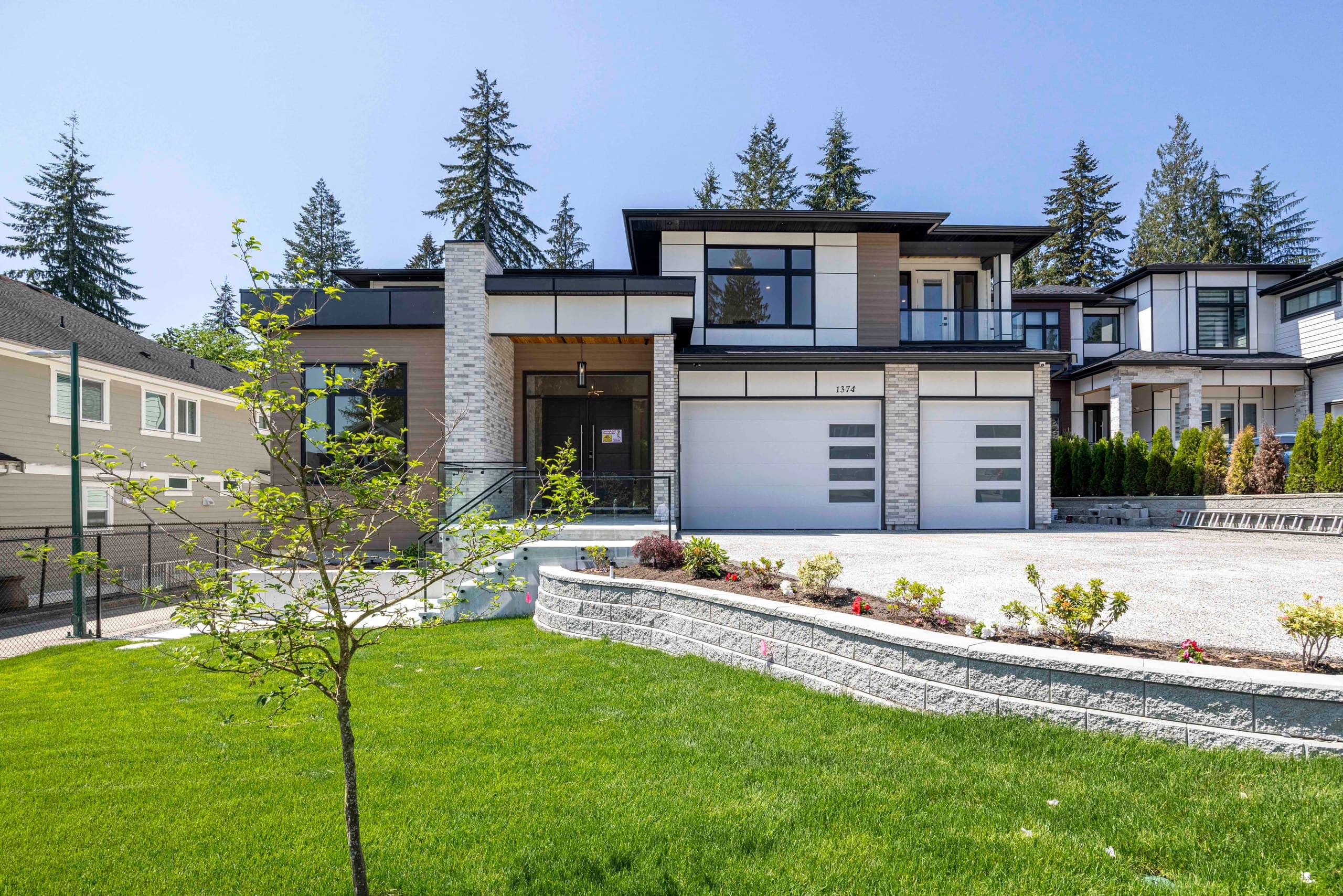 Front elevation in daylight, stone base and dark trim — The Ridge House